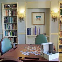 A cozy library setting with a puzzle on the table and bookshelves in the background.
