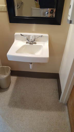 A wall-mounted sink with a faucet in a restroom.