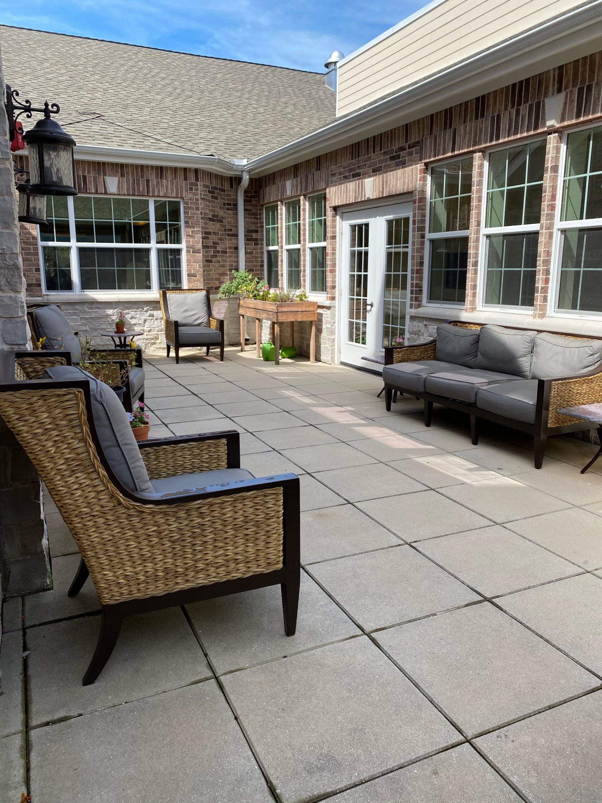 A cozy patio with comfortable outdoor seating and plants.