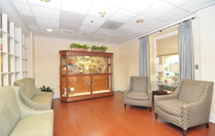 A cozy lobby area featuring comfortable chairs and a large aquarium.