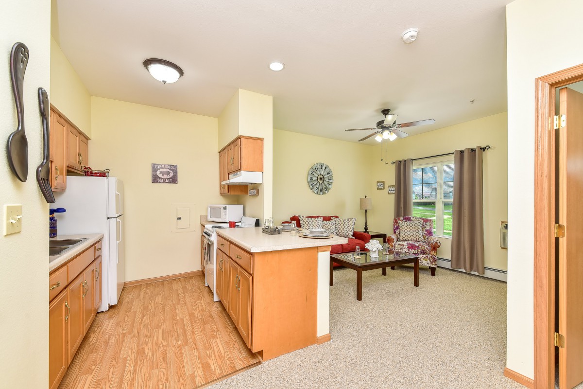 A modern open floor plan apartment featuring a kitchen and living room area.