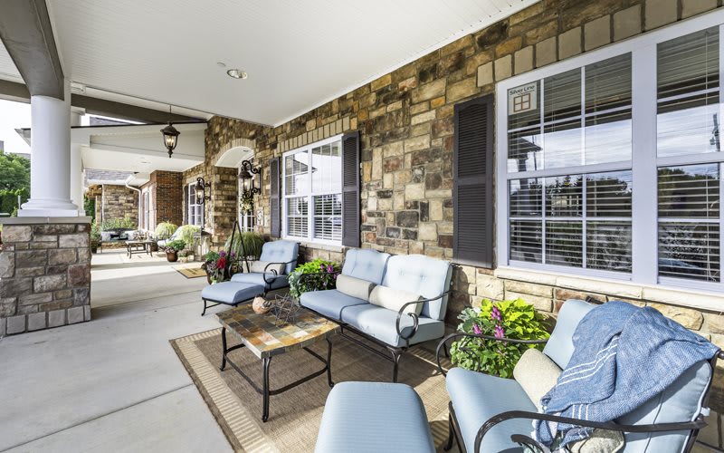 A cozy patio with comfortable seating and lush greenery.