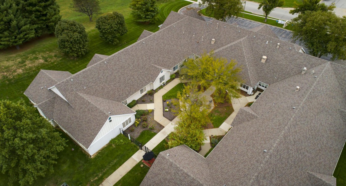 An aerial view of a building complex featuring a central courtyard with trees and walkways.