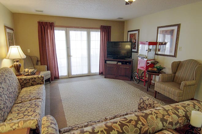A cozy living room featuring a sofa set, television, and popcorn machine.