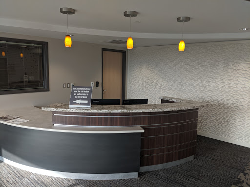 A modern office reception area with sleek furniture and ambient lighting.