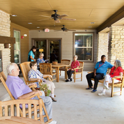A group of people sitting and socializing on a patio.