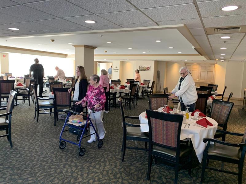 Seniors socializing in a dining room setting.