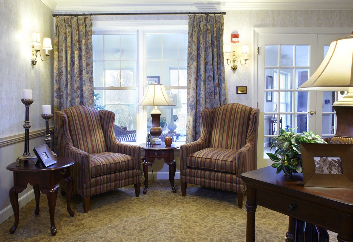 Cozy living room with two armchairs and a lamp by the window.