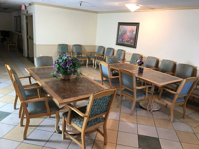 An indoor waiting room with several chairs and tables arranged neatly.