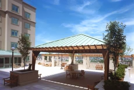 A beautiful outdoor pavilion with a wooden structure, perfect for gatherings under a sunny sky.