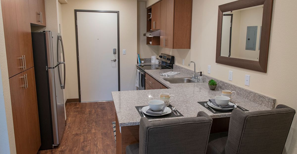 A modern apartment kitchen with a stylish countertop and dining area.