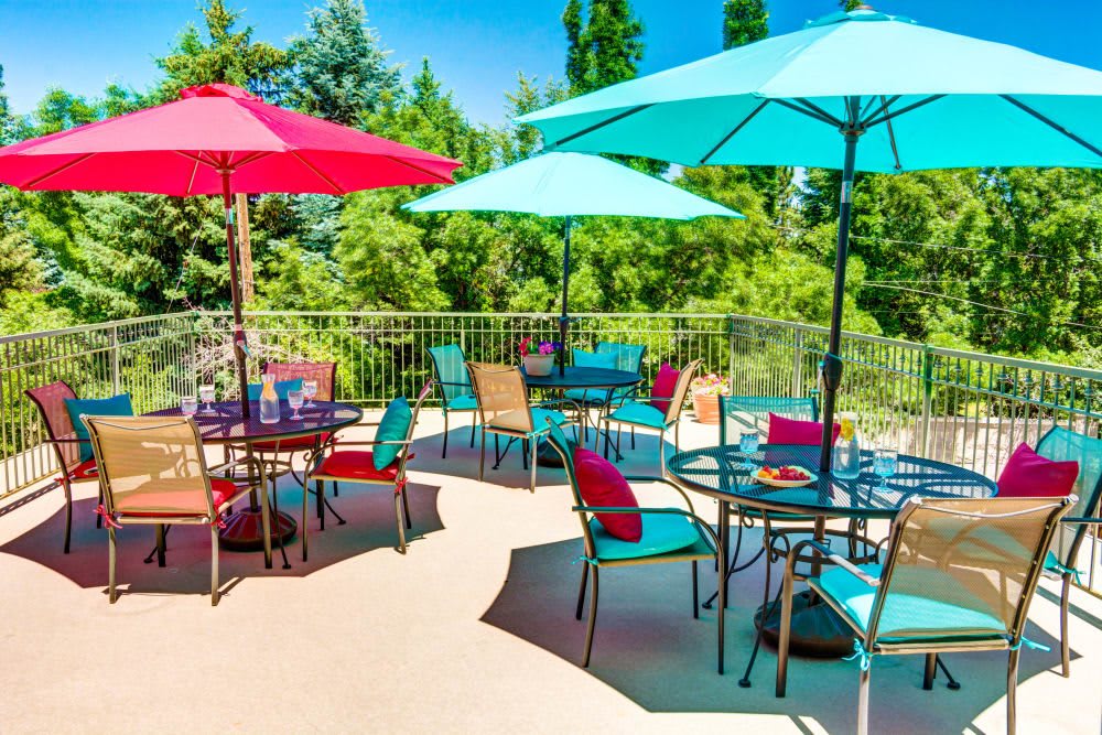 A vibrant patio with colorful umbrellas and seating on a sunny day.