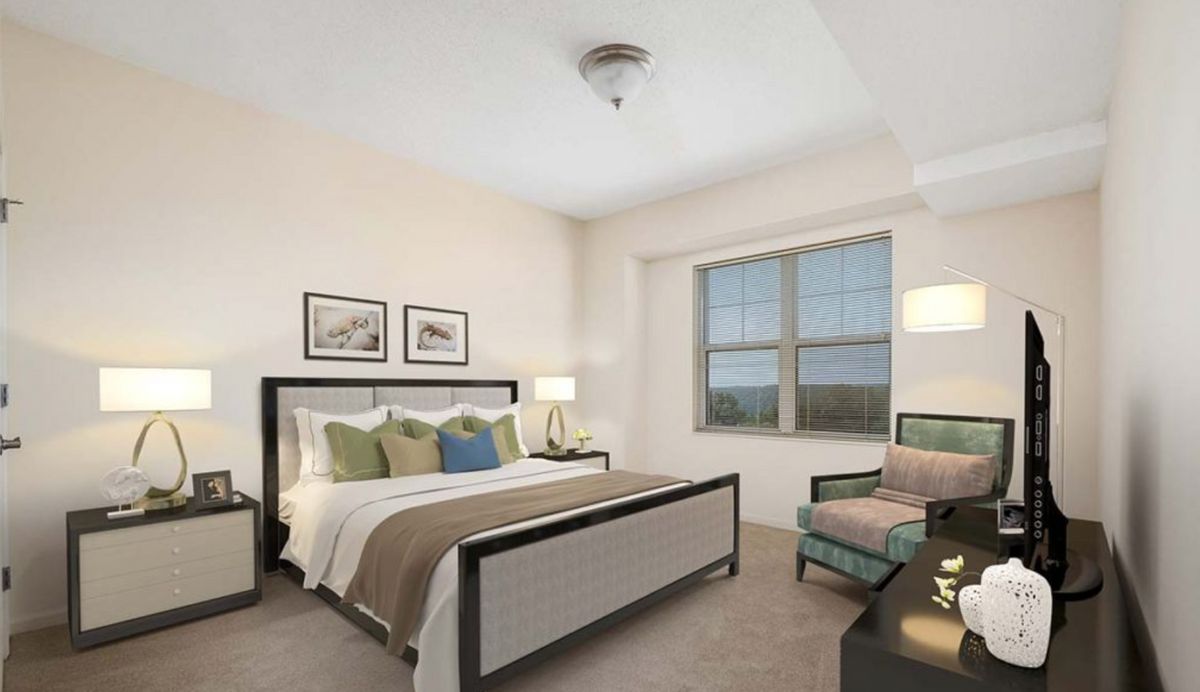 A well-decorated bedroom featuring a double bed, armchair, and ample natural light from the window.
