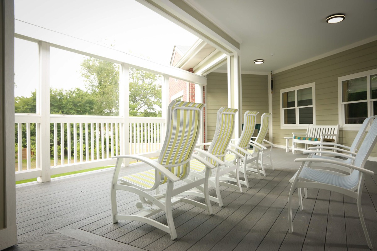 A row of comfortable chairs on a bright, covered porch.