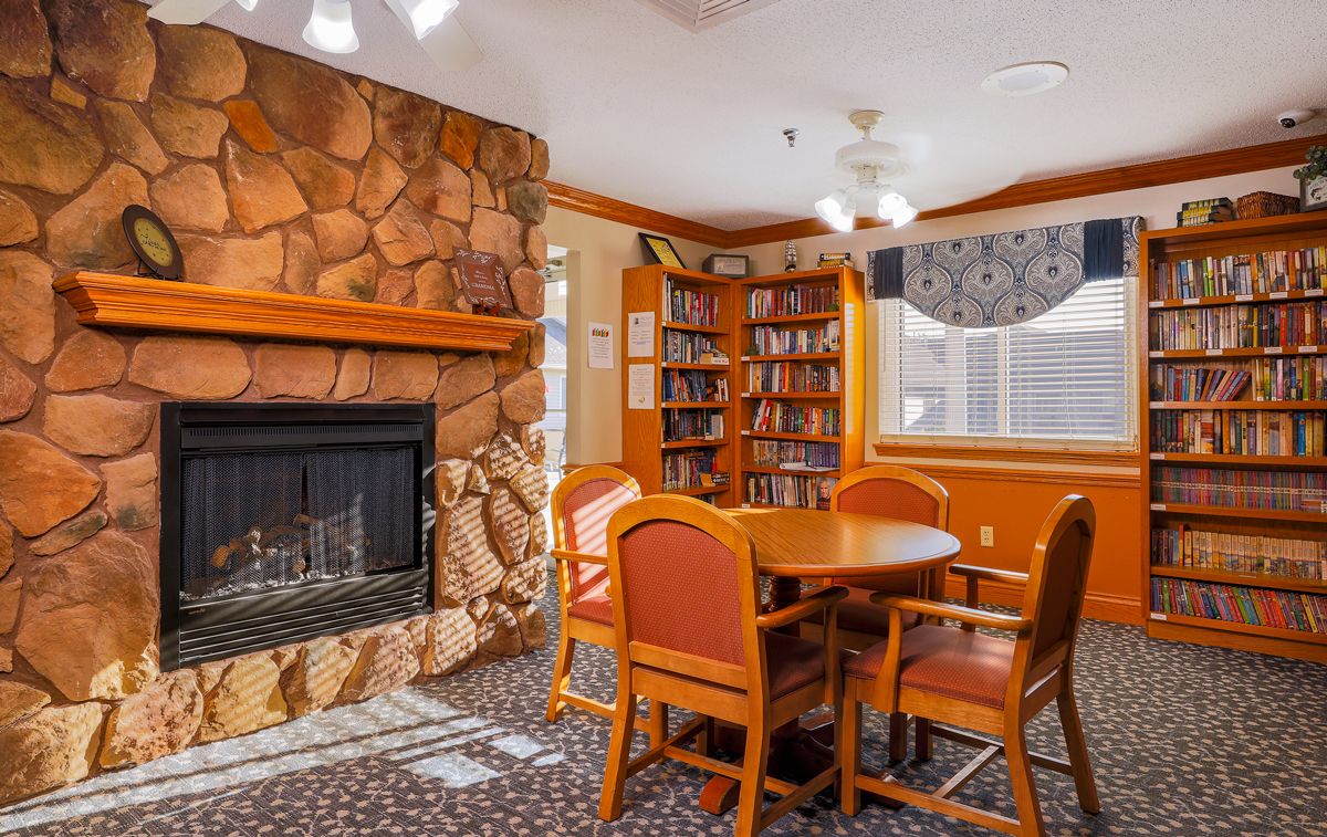 A cozy reading area with a fireplace and a bookshelf.