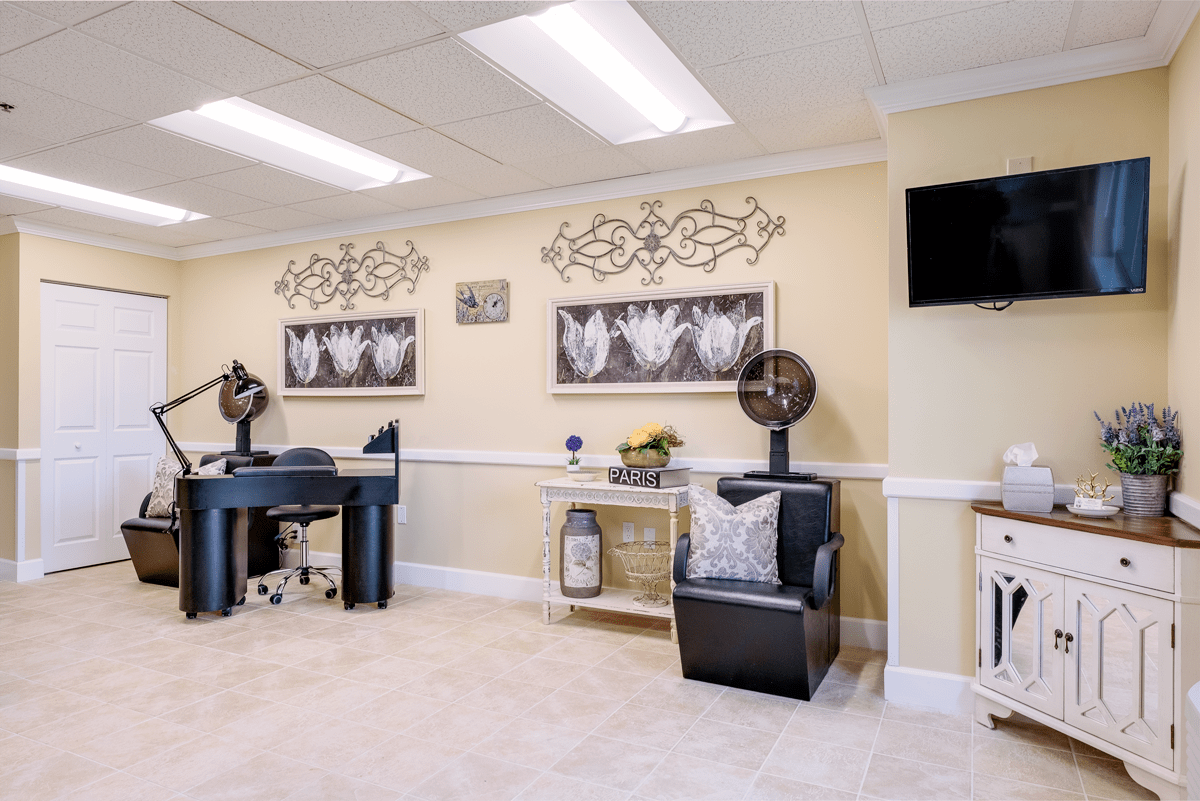 A modern salon interior featuring nail stations and stylish decor.