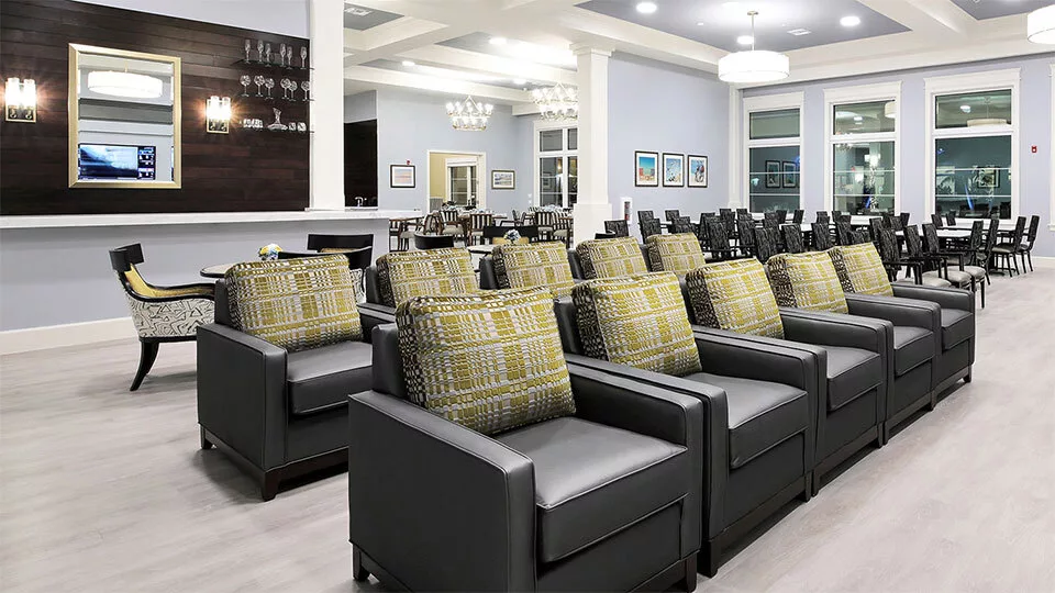 A modern lounge area with rows of comfortable chairs and decorative cushions.