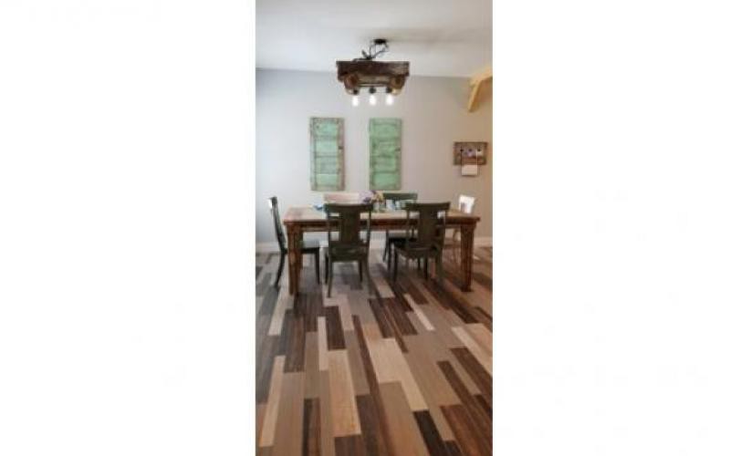 A cozy dining room with a wooden table and chairs, complemented by a unique lighting fixture and stylish wall decor.