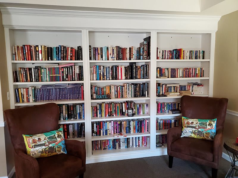 A cozy reading nook featuring a well-stocked bookshelf and comfortable armchairs.