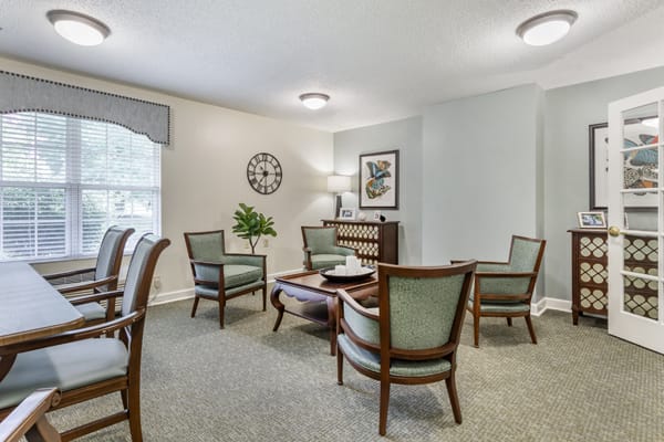 A cozy living room with elegant armchairs and a coffee table.