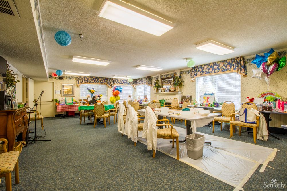 A decorated classroom with tables, chairs, and colorful balloons.