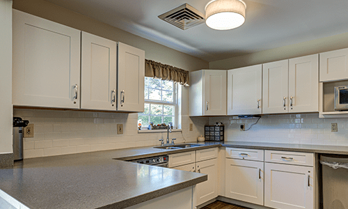A modern kitchen with white cabinets and a sleek countertop.