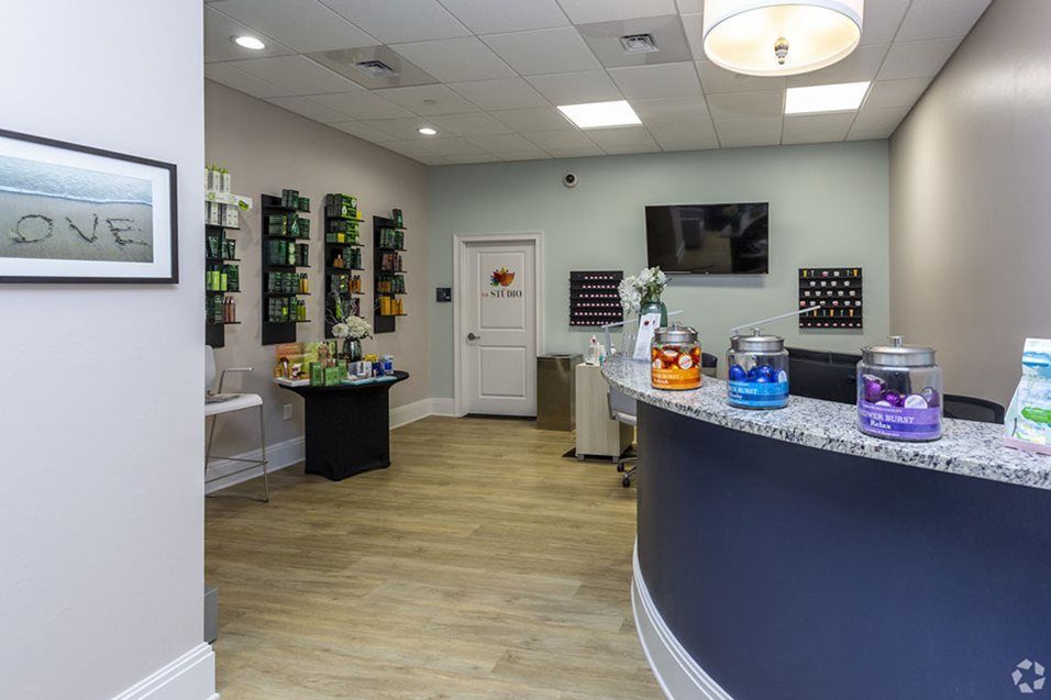 A modern office reception area with a curved desk and seating.