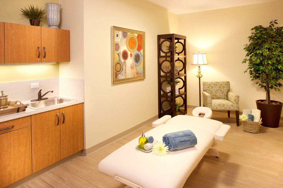 A serene spa room featuring a treatment table with neatly folded towels and inviting decor.