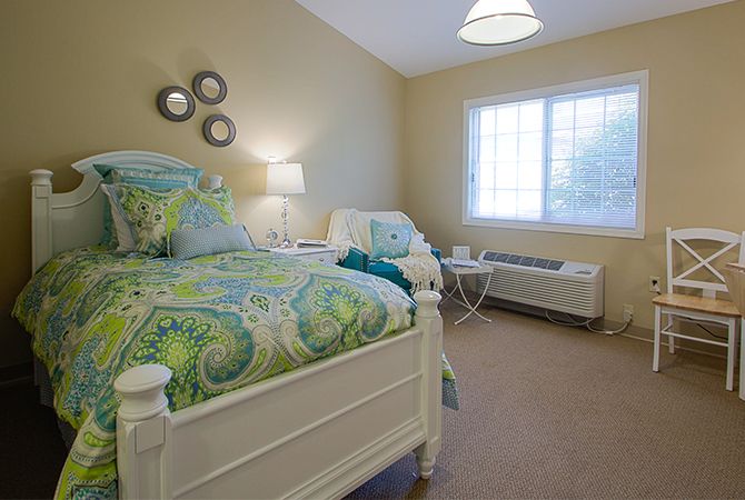 A cozy bedroom with twin beds featuring colorful bedding and soft lighting.