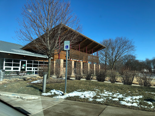 A modern architectural building with a large overhanging roof, situated in a winter landscape.