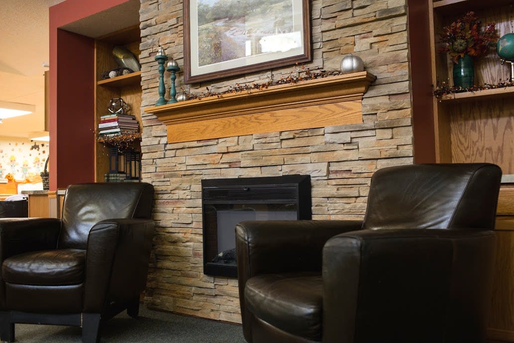 A cozy living room with a stone fireplace and comfortable armchairs.