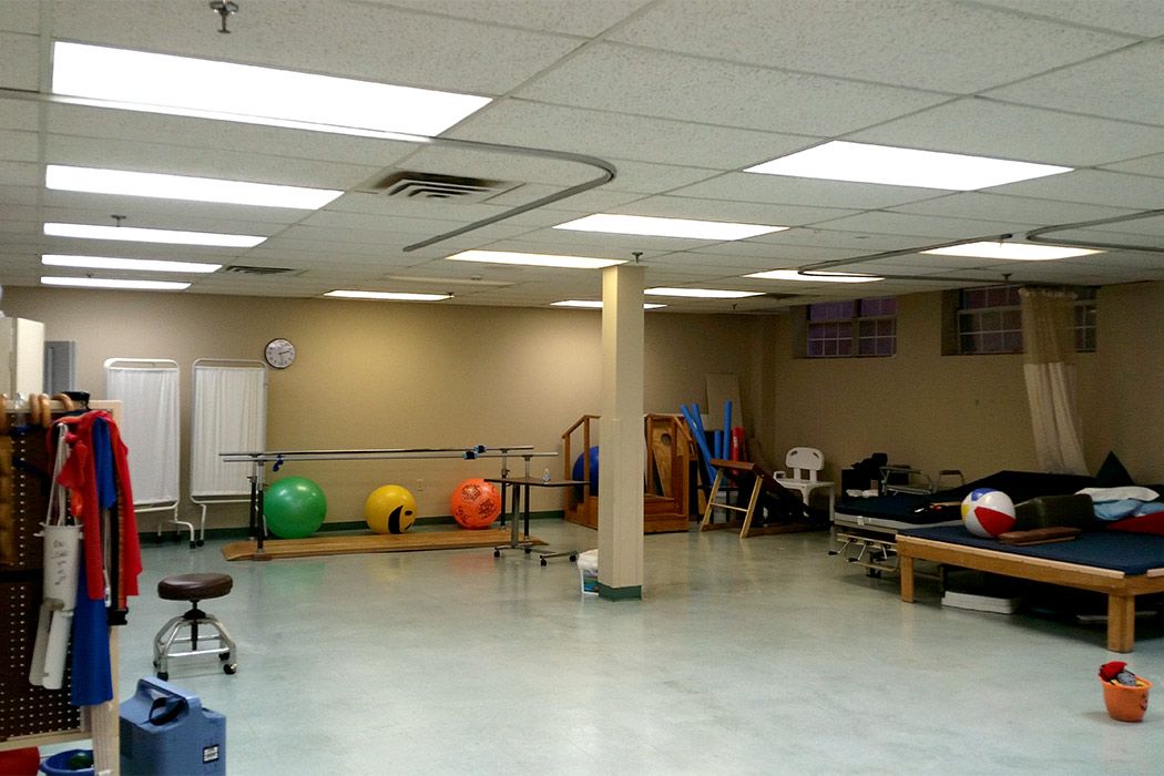A spacious physical therapy room with fitness balls and rehabilitation equipment.