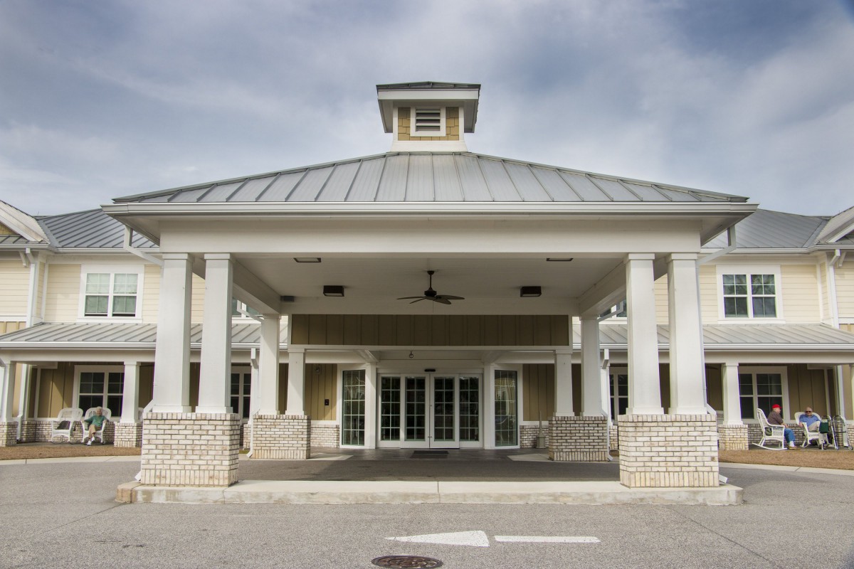 A symmetrical building entrance with prominent columns and a pitched roof.