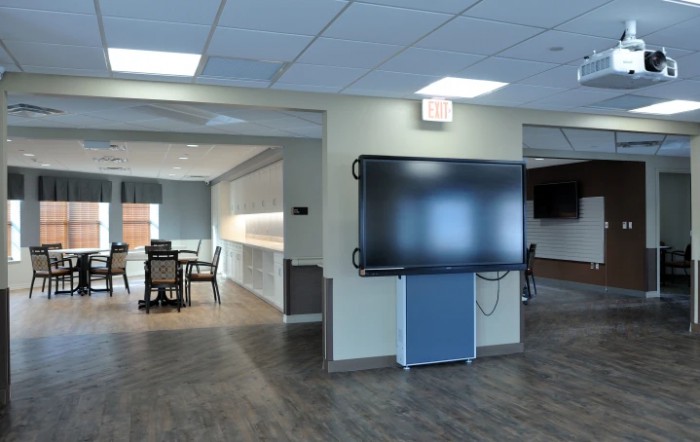 A modern office space with a conference room and a large television screen.