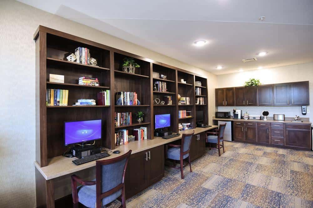 A modern office space featuring computers and bookshelves with a cozy atmosphere.