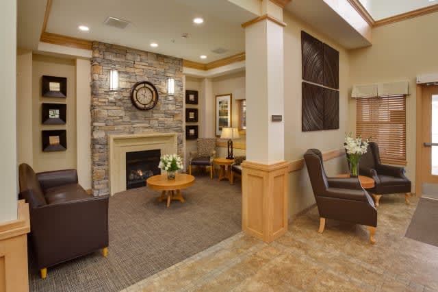 A cozy lobby with a fireplace, comfortable seating, and tasteful decor.