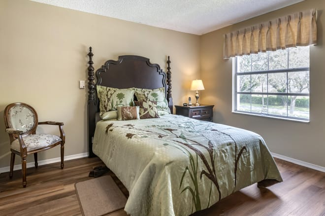 A cozy bedroom with a decorative bedspread and elegant furnishings.