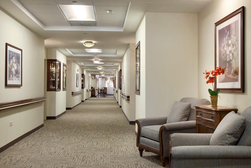 A well-lit hallway with comfortable seating and artwork adorning the walls.