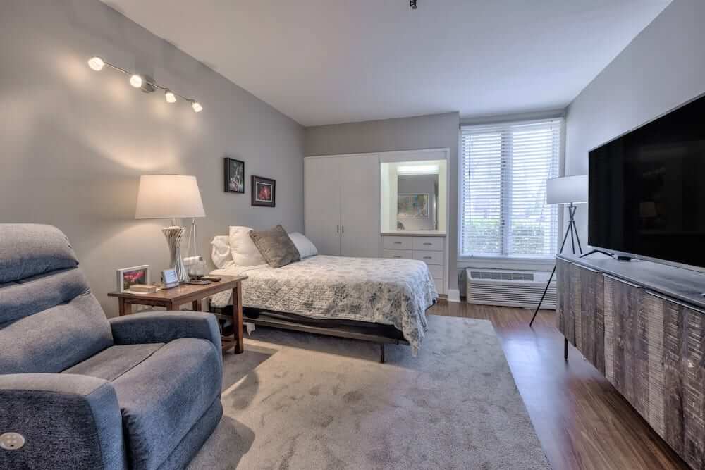 A cozy and well-decorated bedroom with ample natural light.