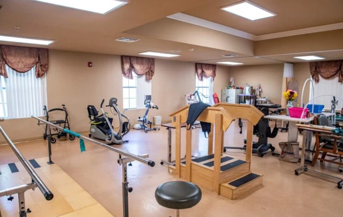 A rehabilitation room equipped with various exercise machines and therapy equipment.