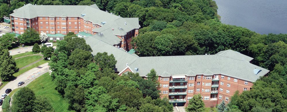 An aerial view of a large building surrounded by dense trees.