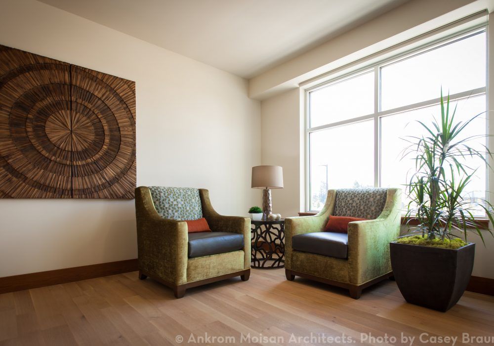 A cozy living room corner with two armchairs by the window, complemented by a side table and lamp.