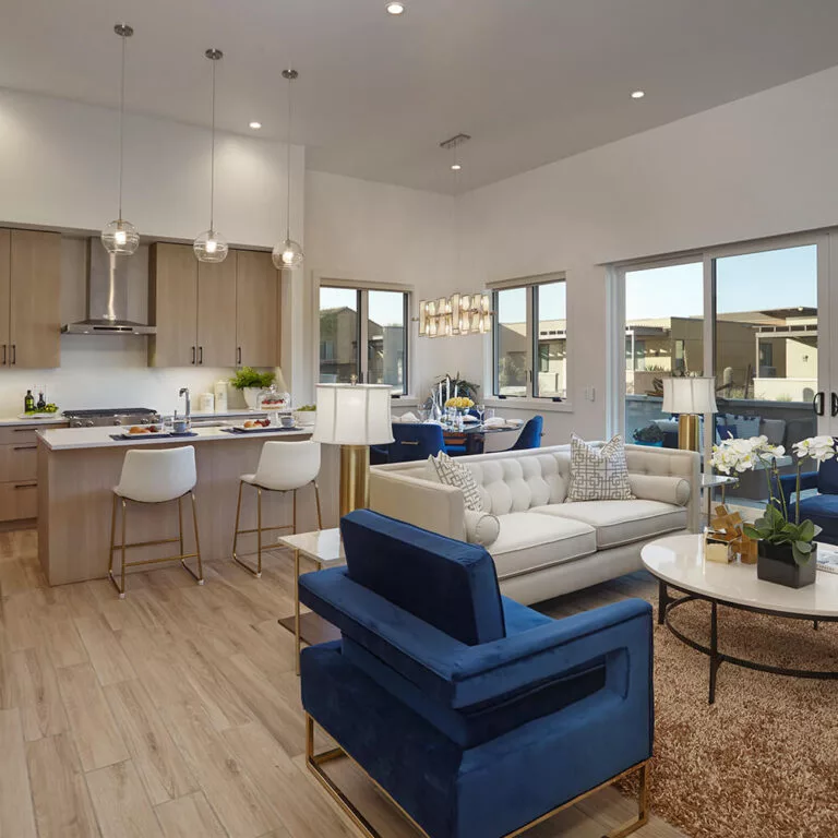 A modern open-concept living area with blue and white furnishings and ample natural light.