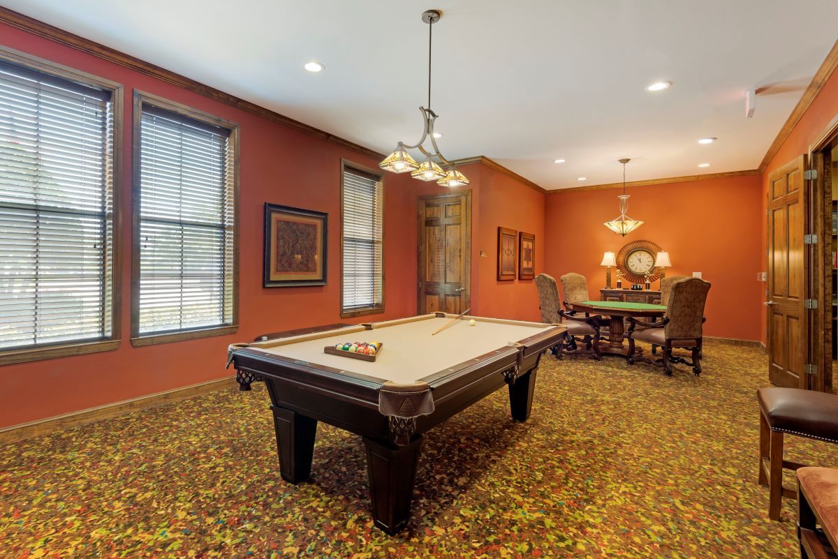 A well-decorated game room featuring a pool table and stylish lighting.