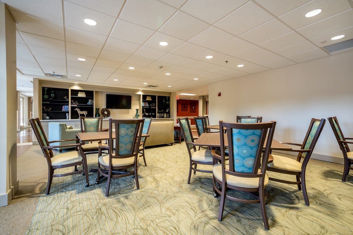 A well-lit dining area with multiple tables and chairs arranged neatly.