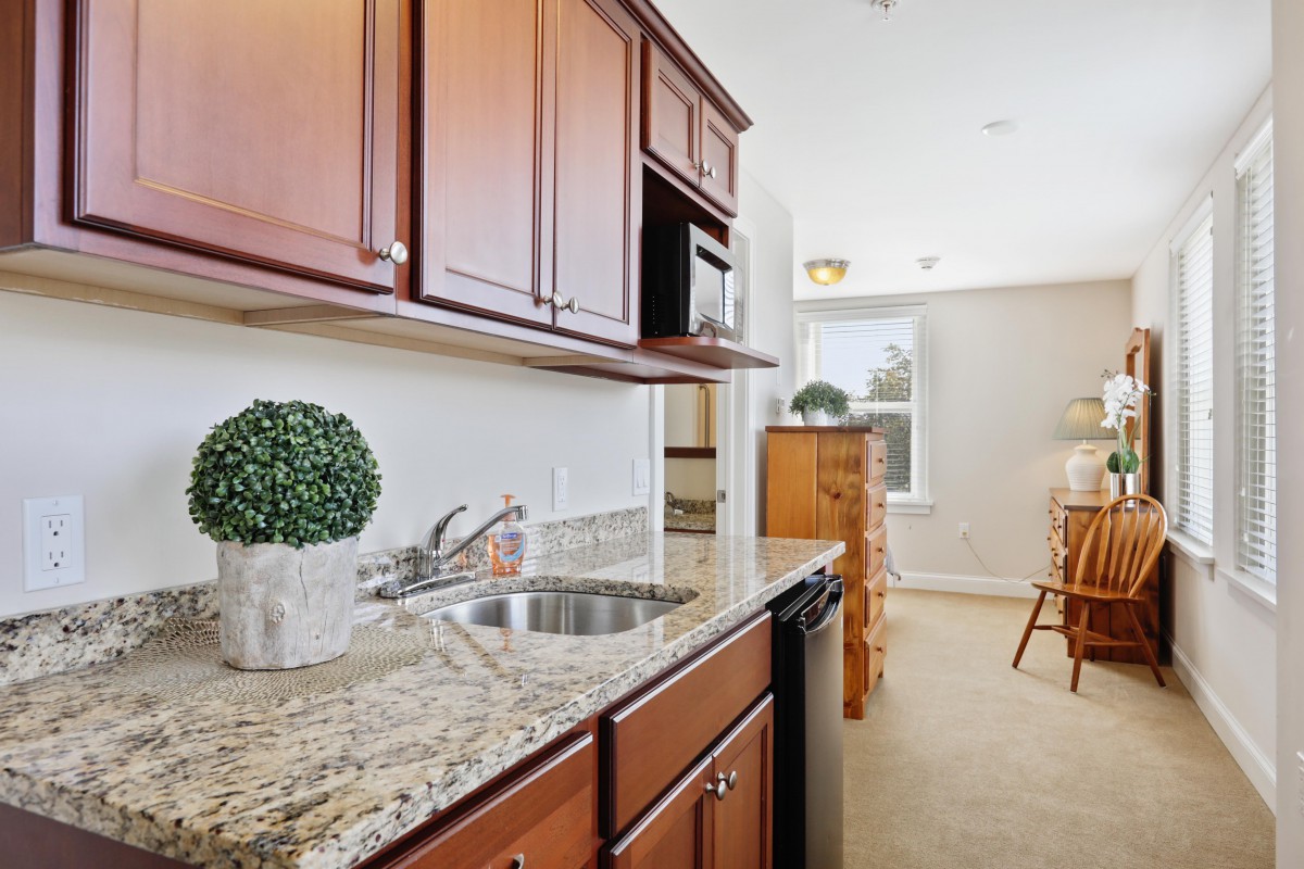 A modern kitchen with granite countertops and wooden cabinets.