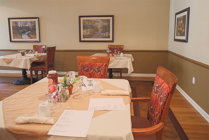 A cozy restaurant dining area with neatly set tables and colorful chairs.