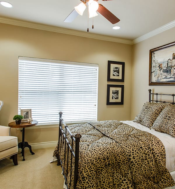 A cozy bedroom with a patterned bedspread and elegant decor.