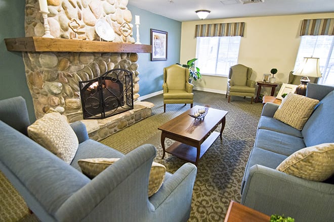 A cozy living room with a stone fireplace, comfortable seating, and a coffee table.