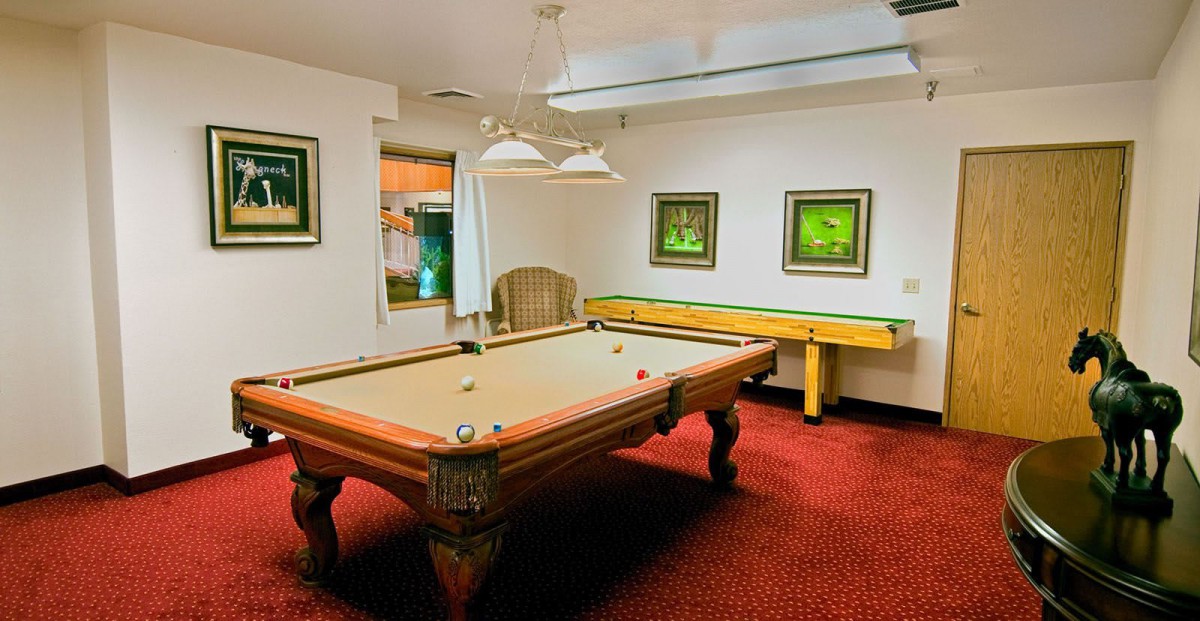 A cozy billiards room featuring a classic pool table and artwork on the walls.